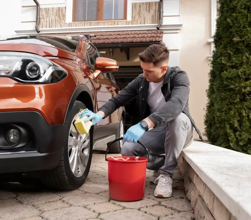 Lavage auto à domicile Saint-Exupéry-les-Roches : professionnel intervenant sur un véhicule